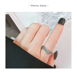 Detail of silver angel wing ring with vintage feather texture worn on the index finger