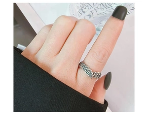 Macro detail of retro sterling silver wing ring with vintage engraved feather texture