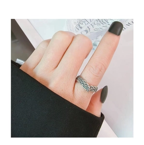 Close-up of vintage silver feather open ring with intricate textures on index finger