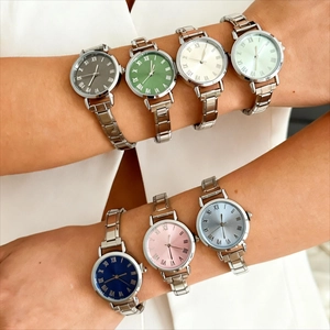 Détail de montres en acier inoxydable avec cadrans colorés et chiffres romains