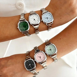 Détail montrant six cadrans carrés en vert, blanc, bleu, noir, rose et menthe sur bracelet inox