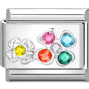 Makroaufnahme eines Edelstahl-Gliedcharms mit einer bunten fünfblättrigen Strassblume