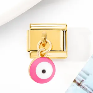 Makroaufnahme von goldenem Italian Charm Link mit rosa Evil Eye Emaille-Anhänger für Armbänder