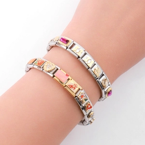 Detail view of two Italian charm bracelets on wrist featuring pink enamel and heart charms