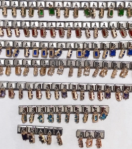 Detaillierte Makroansicht bunter Edelstein-Charms in polierten Edelstahlsockeln für Armbänder