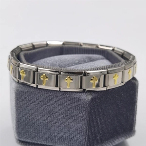 Close-up of modular stainless steel bracelet with golden 3D cross motifs on silver links