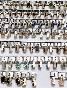 Makroaufnahme von Charm-Armbändern mit bunten Edelstein-Anhängern und Edelstahlgliedern