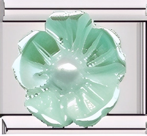 Vue macro d'une base en métal argenté avec un pendentif fleur verte translucide