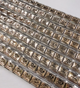Detailed close-up of Italian modular charm links with various occupation icons in silver and gold