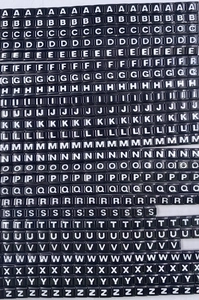 Detailweergave van de roestvrijstalen Italiaanse bedels met witte letters alfabet A-Z