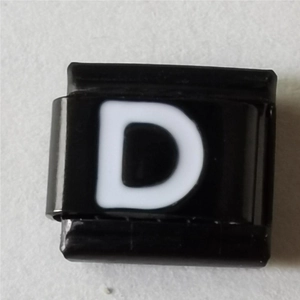 Macro-opname van Italiaanse armband link met witte letter D op zwart staal
