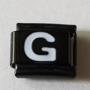 Detailopname van zwart roestvrijstalen Italiaanse armband schakel met witte letter G