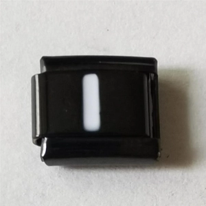Detailweergave van een zwarte roestvrijstalen modulaire link met witte letter I gravure