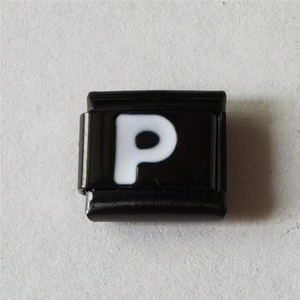 Detail van modulaire roestvrijstalen bedel met witte letter P op zwart emaille decor