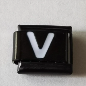 Macro-opname van Italiaanse armband schakel met witte letter V op gepolijst zwart
