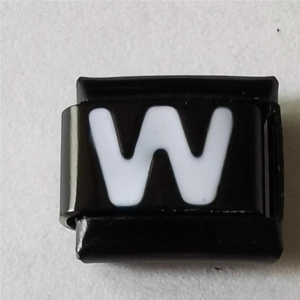 Macro-opname van zwarte roestvrijstalen bedel met witte letter W voor DIY-armbanden