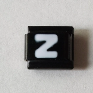 Macro-opname van een zwart emaille bedeltje met een wit letter Z-ontwerp erop