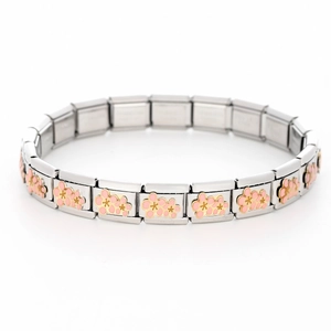 Macro detail of 9mm stainless steel modular links with pink enamel flowers and gold trim