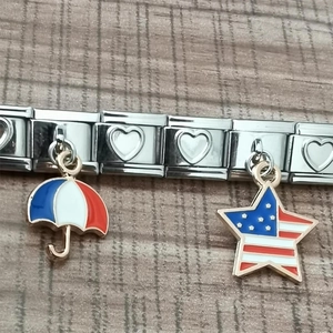 Macro shot of Italian charm bracelet links featuring US star and French umbrella charms