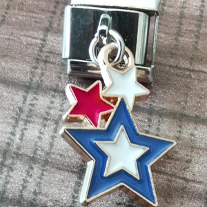 Macro shot of red white and blue enamel star charms on a stainless steel link