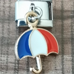 Detailed close-up of a red white and blue enamel umbrella charm on an Italian link
