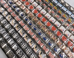 Dettaglio macro di maglie per charm italiani in acciaio inossidabile e smalto colorato