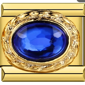 Makro-Detail des italienischen Gold-Charms mit einem großen ovalen dunkelblauen Saphir