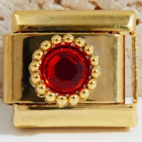 Makroansicht des 18K Gold-Glieds mit rotem Edelstein und Perlenrand für Charm-Armbänder