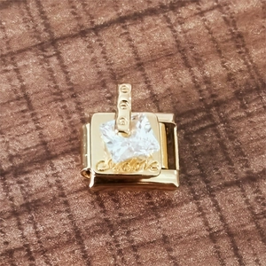 Detail eines 18K Goldmoduls mit quadratischem Kristall und Cousins-Gravur