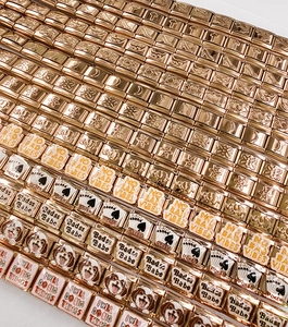Dettaglio di charms italiani in oro rosa con icone incise e slogan in smalto colorato