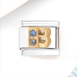 Macro shot of silver stainless steel charm link with gold letter B and blue zircon stones