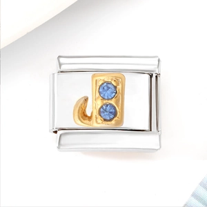 Detail of Italian charm bracelet link featuring a gold letter J with blue crystals