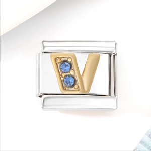 Detail of stainless steel Italian charm link with golden letter V and blue crystals