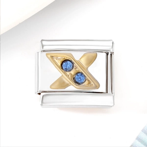 Macro detail of Italian style modular charm with gold letter X and blue gemstones