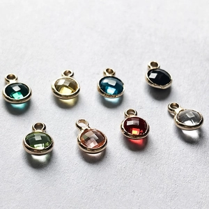 Detailaufnahme facettierter Zirkon-Anhänger in acht Farben mit Goldbeschichtung