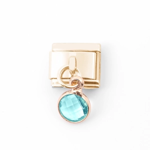 Detaillierte Makroaufnahme eines goldenen Edelstahl-Moduls mit blauem Zirkonstein-Anhänger