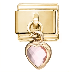 Gros plan d'un charm modulaire en acier doré avec un pendentif en cristal rose en cœur