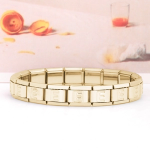 Dettaglio ravvicinato del bracciale a maglie in acciaio inossidabile dorato con lettera E