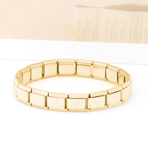 Dettaglio del bracciale a maglie in acciaio inossidabile dorato con lettera M incisa