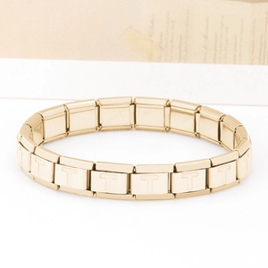 Dettaglio macro di una maglia per bracciale italiano modulare dorato con lettera T incisa