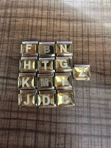Detalle de 13 dijes de letras con purpurina dorada y plateada para pulsera italiana
