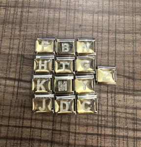 Detalle de eslabones dorados con purpurina para pulsera italiana DIY con varias letras