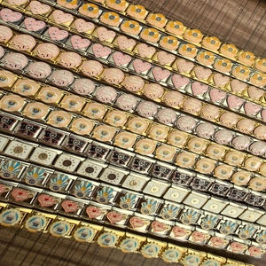 Detailed view of Italian charm links with enamel heart and evil eye designs for DIY bracelets