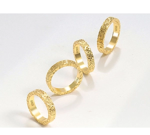 Detailed macro view of S925 sterling silver rings with hammered texture and gold plating