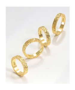 Close-up of four gold S925 sterling silver rings with textured crushed ice hammered finish