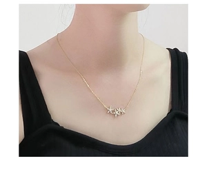 Close-up of golden necklace featuring three elegant flower pendants with pavé zircons