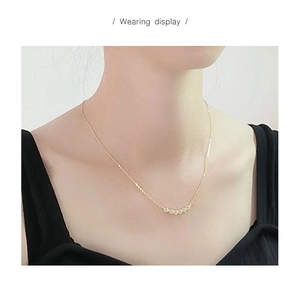 Close-up van een delicate S925 zilveren ketting met glanzende zirkoonstenen om de nek