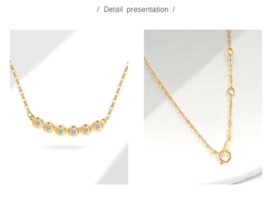 Detail van gouden smile ketting met bezel-gezette zirkoon en verstelbare kettingsluiting
