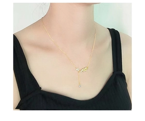 Primo piano della collana in argento S925 dorato con ciondolo a foglia e goccia su modella
