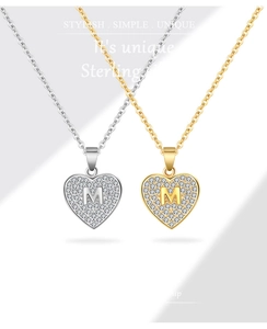 Detailopname van hartvormige letter M hanger met gezette zirkonia stenen op zilver